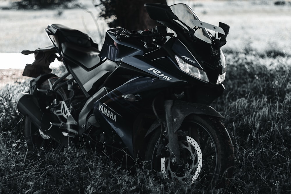 black honda sports bike on green grass field during daytime