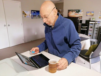 man in blue sweater using macbook pro