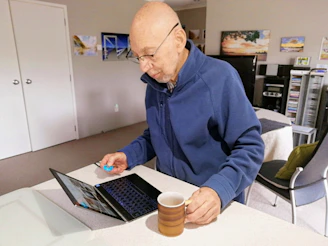 man in blue sweater using macbook pro