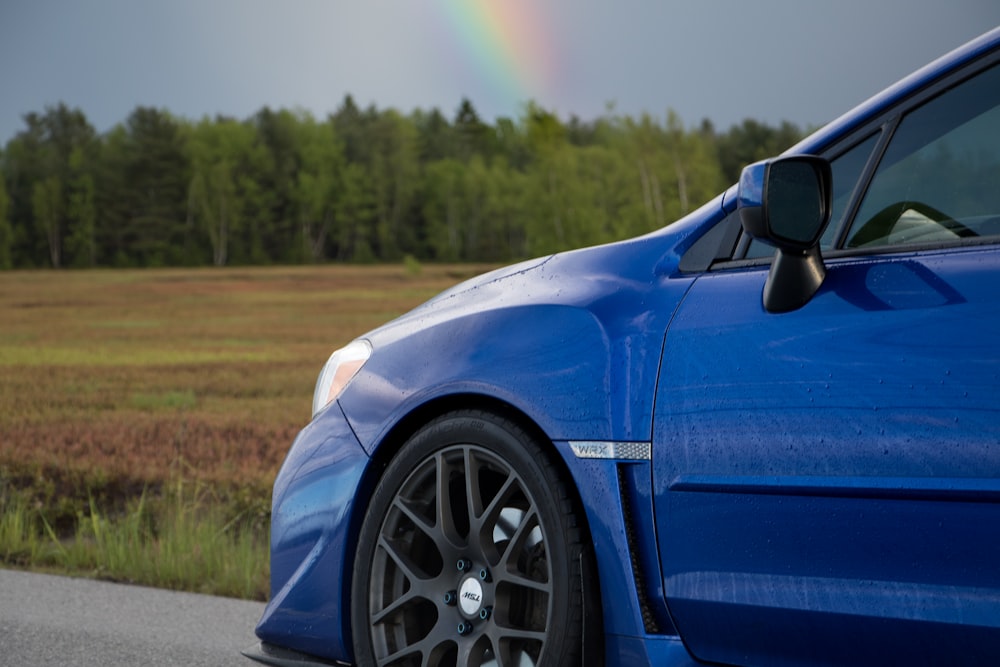 blue car on brown field during daytime