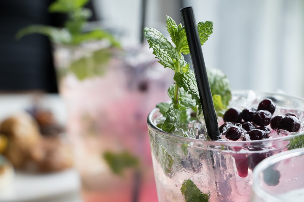 clear drinking glass with ice and black berries