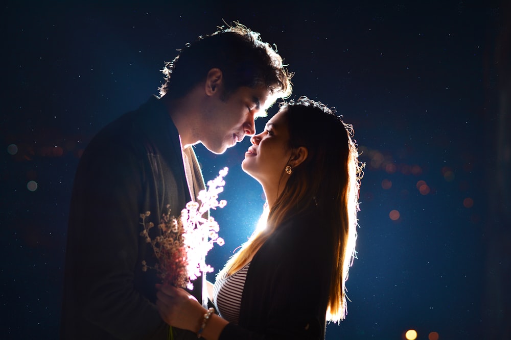 man and woman kissing during night time