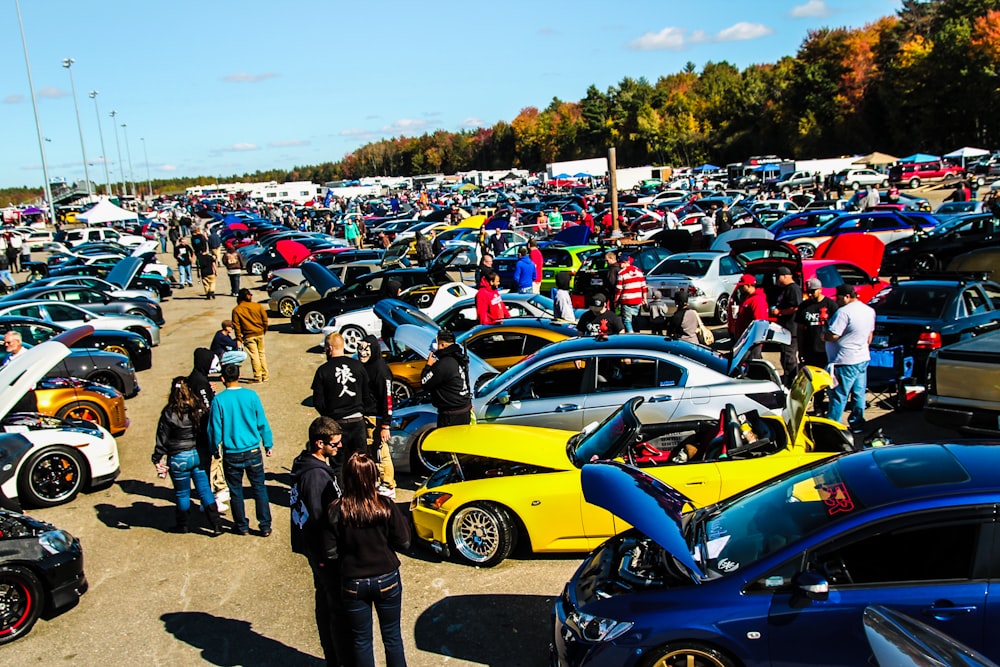 people standing beside blue and yellow cars during daytime