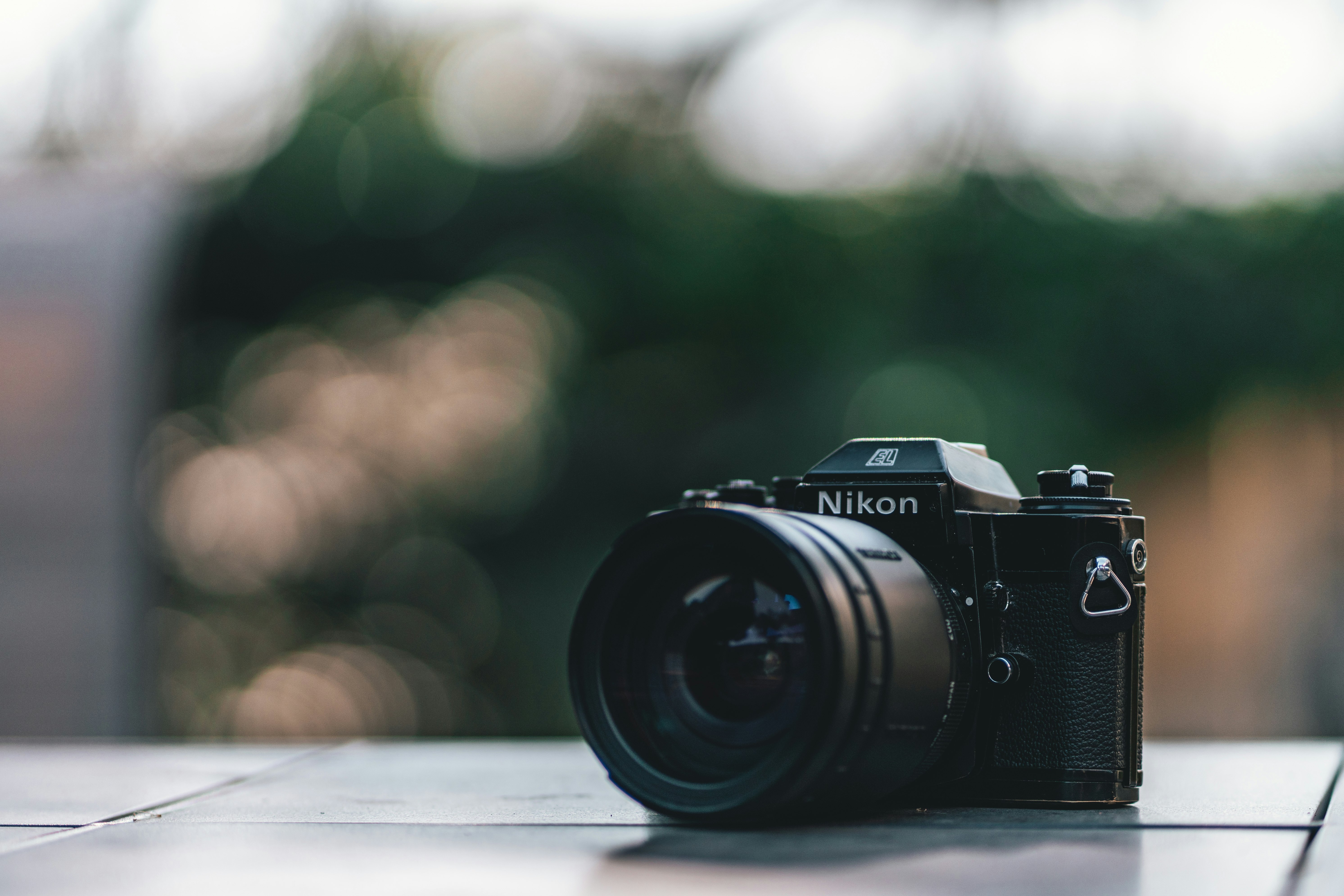 black nikon dslr camera on white wooden table