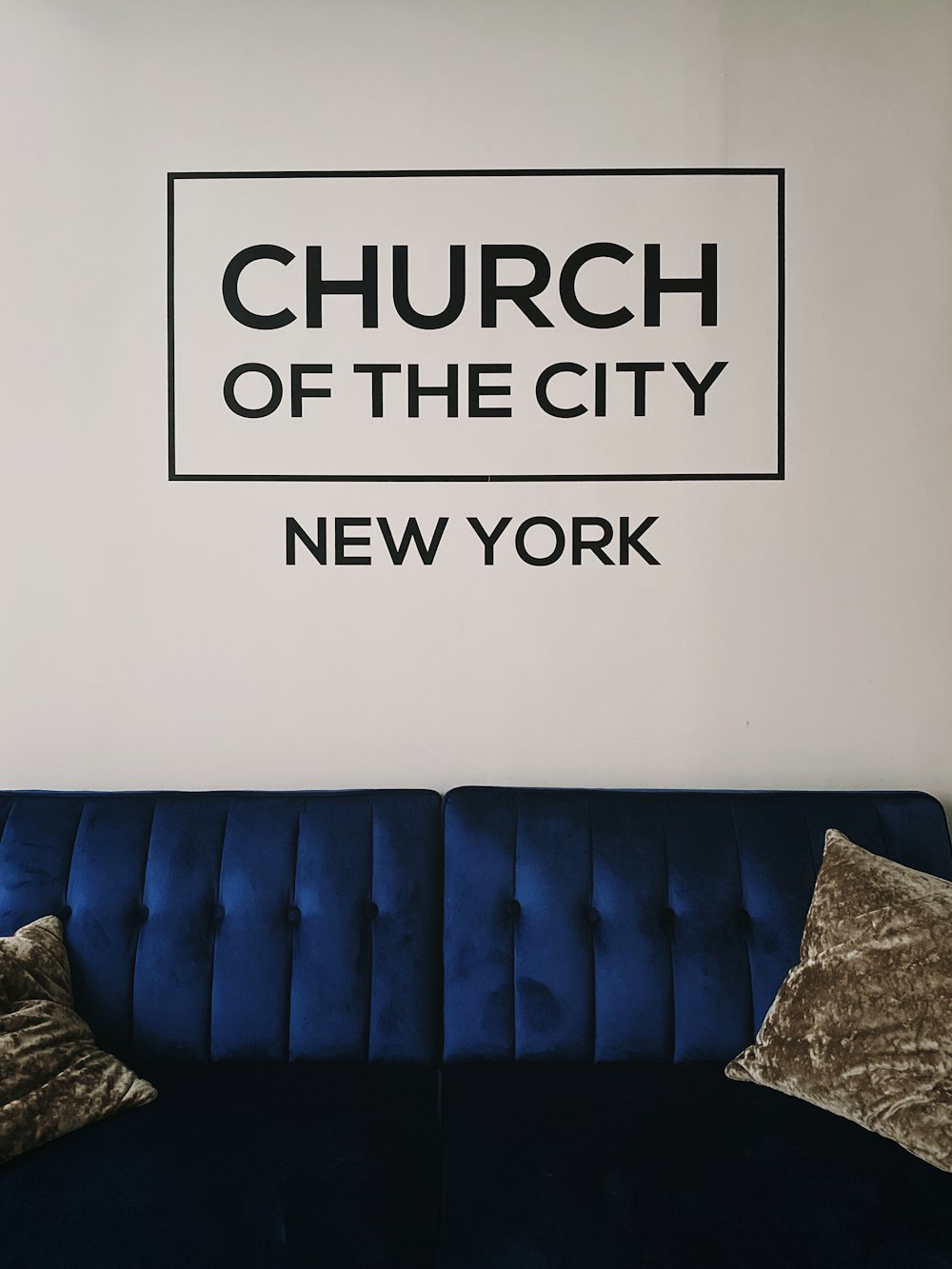 blue couch beside white wall