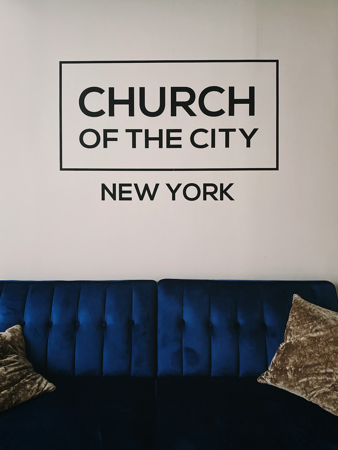 blue couch beside white wall