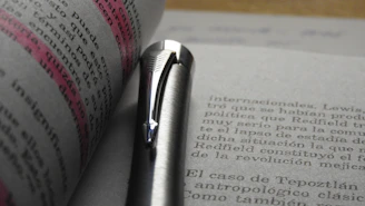 Close-up of a student’s hand highlighting notes on a printed study guide with a gold pen.