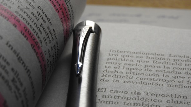 A close-up of a safety manual with highlighted sections and a pen resting on it.