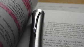 Close-up of hands writing on a legal textbook with vibrant highlights.