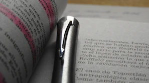 Open legal documents with a pen resting on top, highlighting detailed text