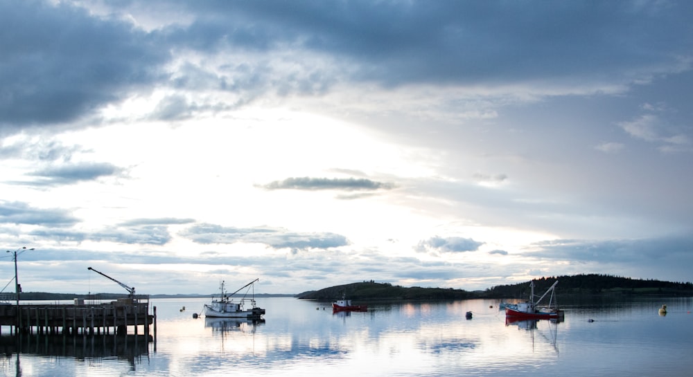 white and black boat on body of water under cloudy sky during daytime