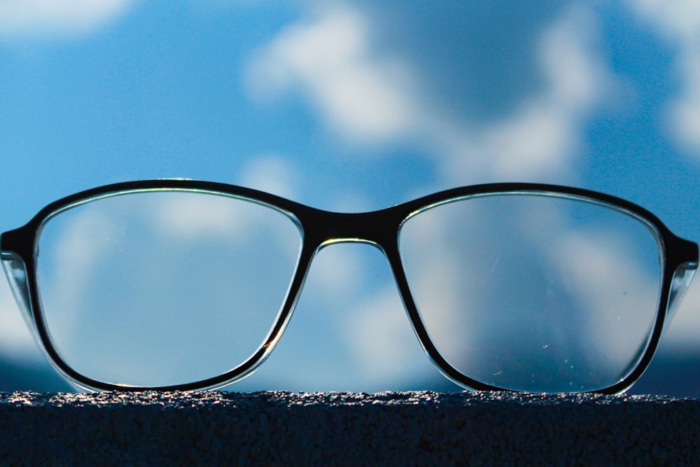 black framed eyeglasses on snow covered ground under blue sky during daytime