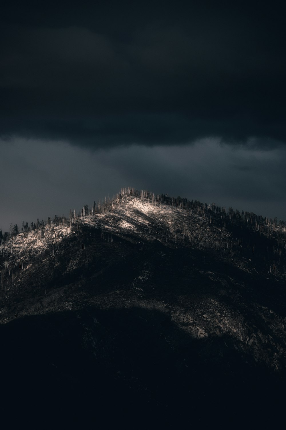 black and white mountain under cloudy sky