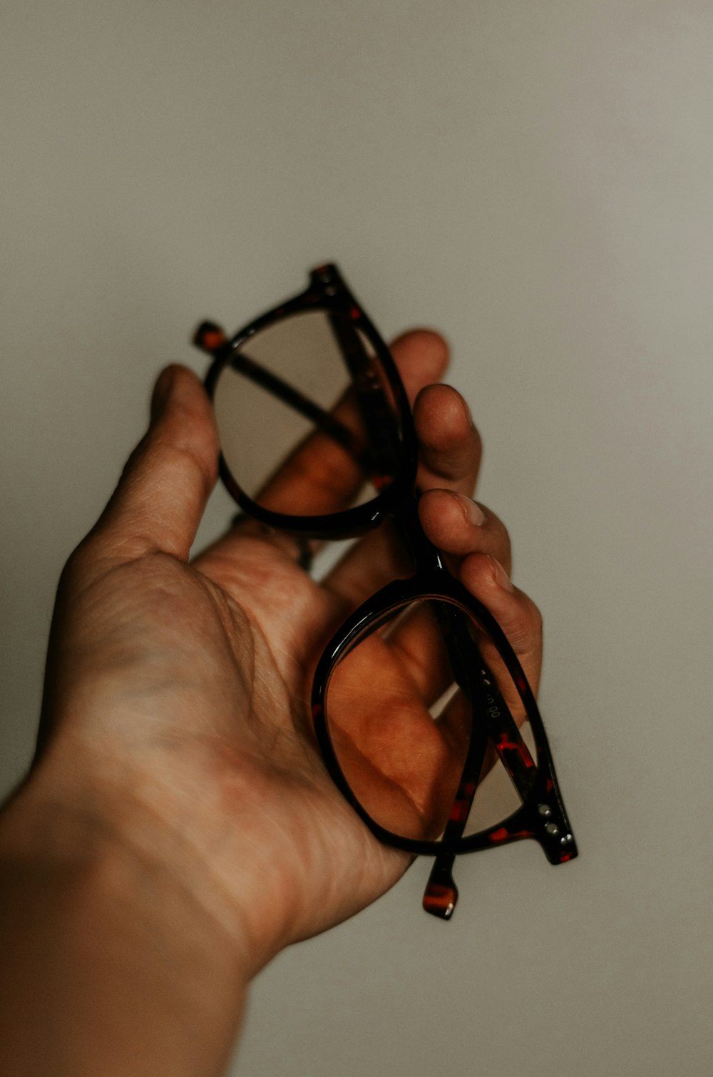 person holding black framed eyeglasses