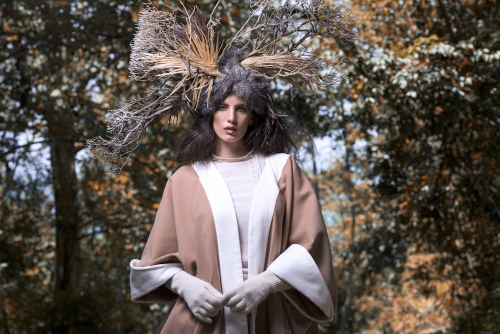 woman in white long sleeve dress standing under brown tree