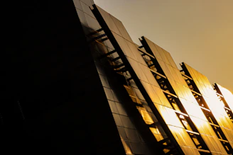 Elegant modern luxury apartment building facade with golden accents at sunset.