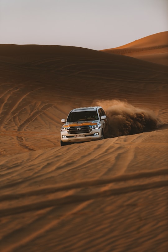 white chevrolet car on desert in Abu Dhabi United Arab Emirates