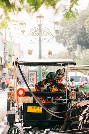 man in black and red floral jacket riding on black and brown auto rickshaw during daytime