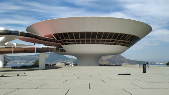 white concrete building under blue sky during daytime in Niterói Contemporary Art Museum Brasil