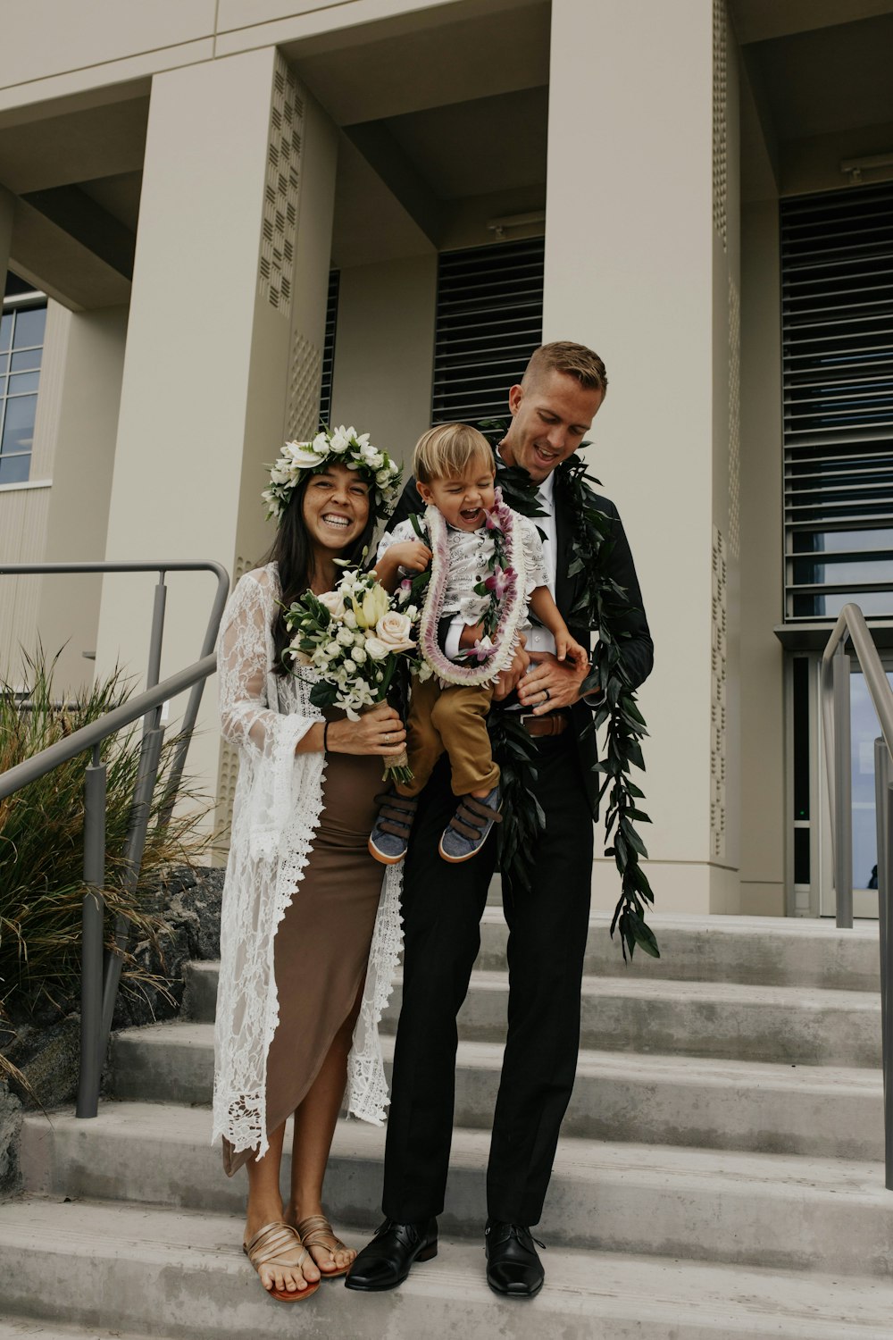 man in black suit jacket holding woman in white dress