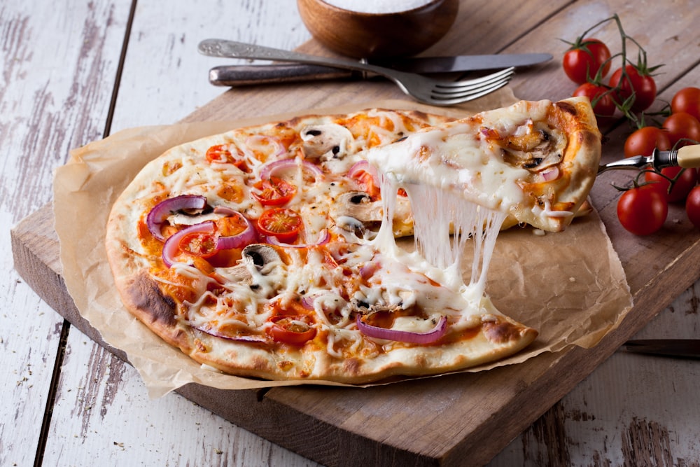 pizza with cheese toppings on a wooden tray
