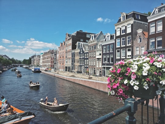 people riding on boat on river near buildings during daytime in Rijksmuseum Netherlands