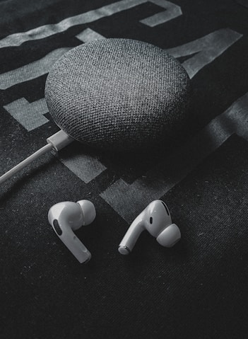 white earbuds on black textile