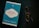 A blue book titled 'Go Kiss the World' by Subroto Bagchi is placed next to a pair of round eyeglasses on a dark surface. The book cover features a white and black circular design with text and a small penguin logo at the top.