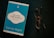 A blue book titled 'Go Kiss the World' by Subroto Bagchi is placed next to a pair of round eyeglasses on a dark surface. The book cover features a white and black circular design with text and a small penguin logo at the top.