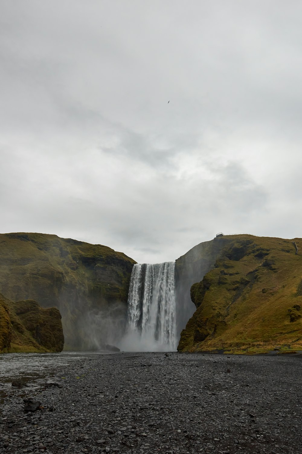 waterfalls under white cloudy sky during daytime