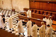 A group of monks deep in philosophical debate within a traditional monastic hall.