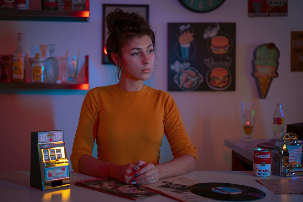 woman in yellow crew neck long sleeve shirt sitting at the table