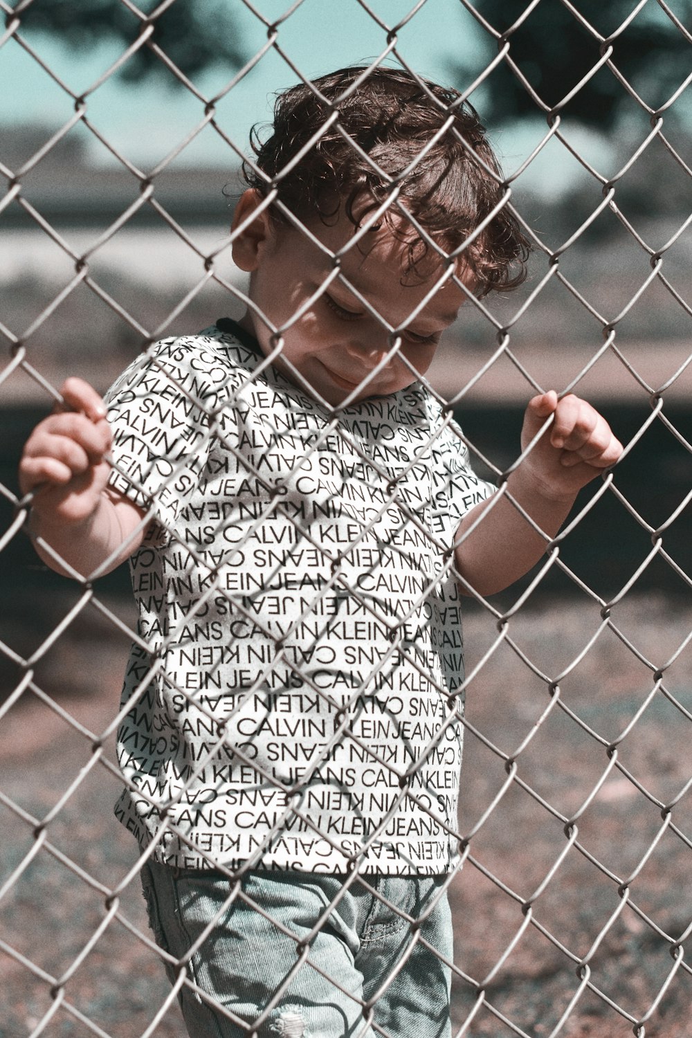 woman in black and white shirt standing beside fence