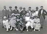 A group of diverse men dressed in casual and formal attire outdoors.