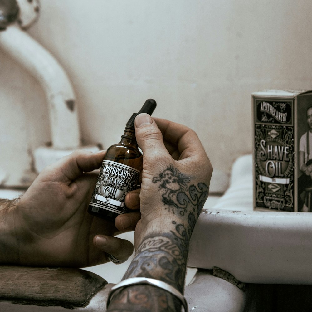 person holding black and silver jack daniels bottle