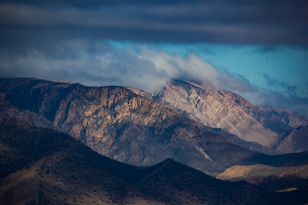 brown and gray mountains under gray clouds