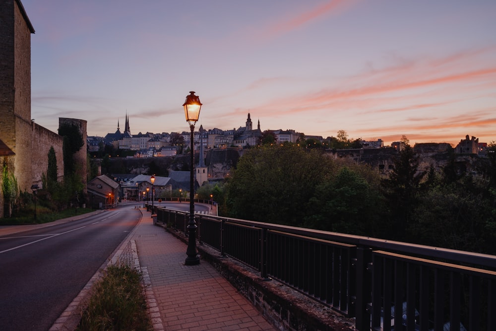 Schwarze Straßenlaterne in der Nähe von schwarzem Metallzaun während des Sonnenuntergangs