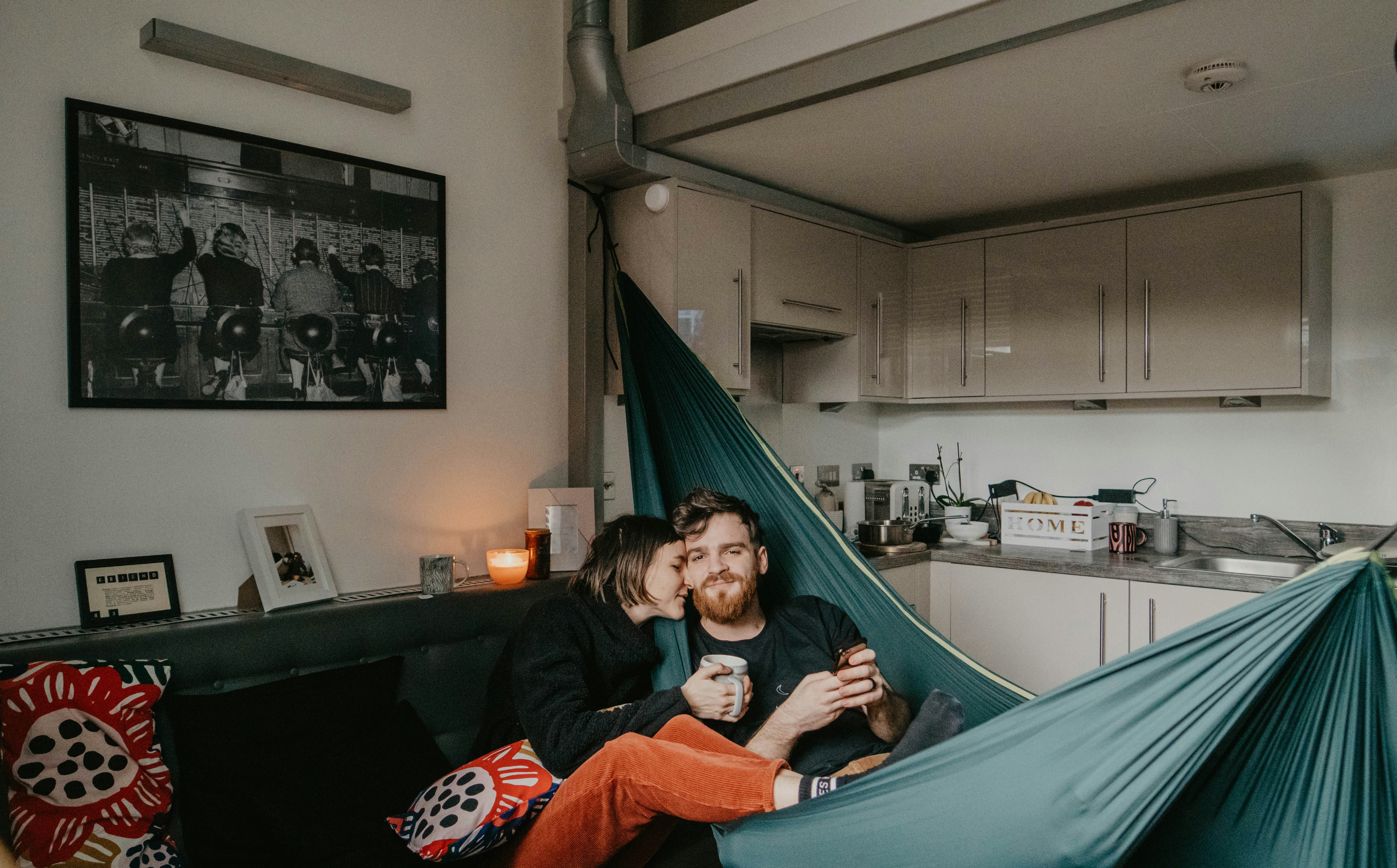 Frau in schwarzer Jacke liegt auf blauer Hängematte