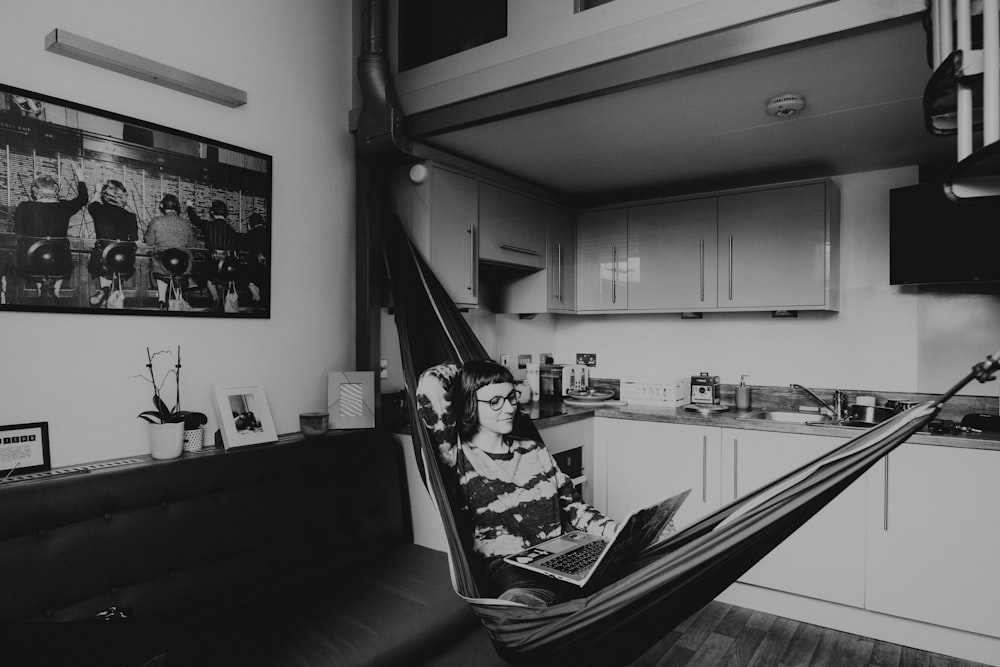 grayscale photo of woman sitting on chair