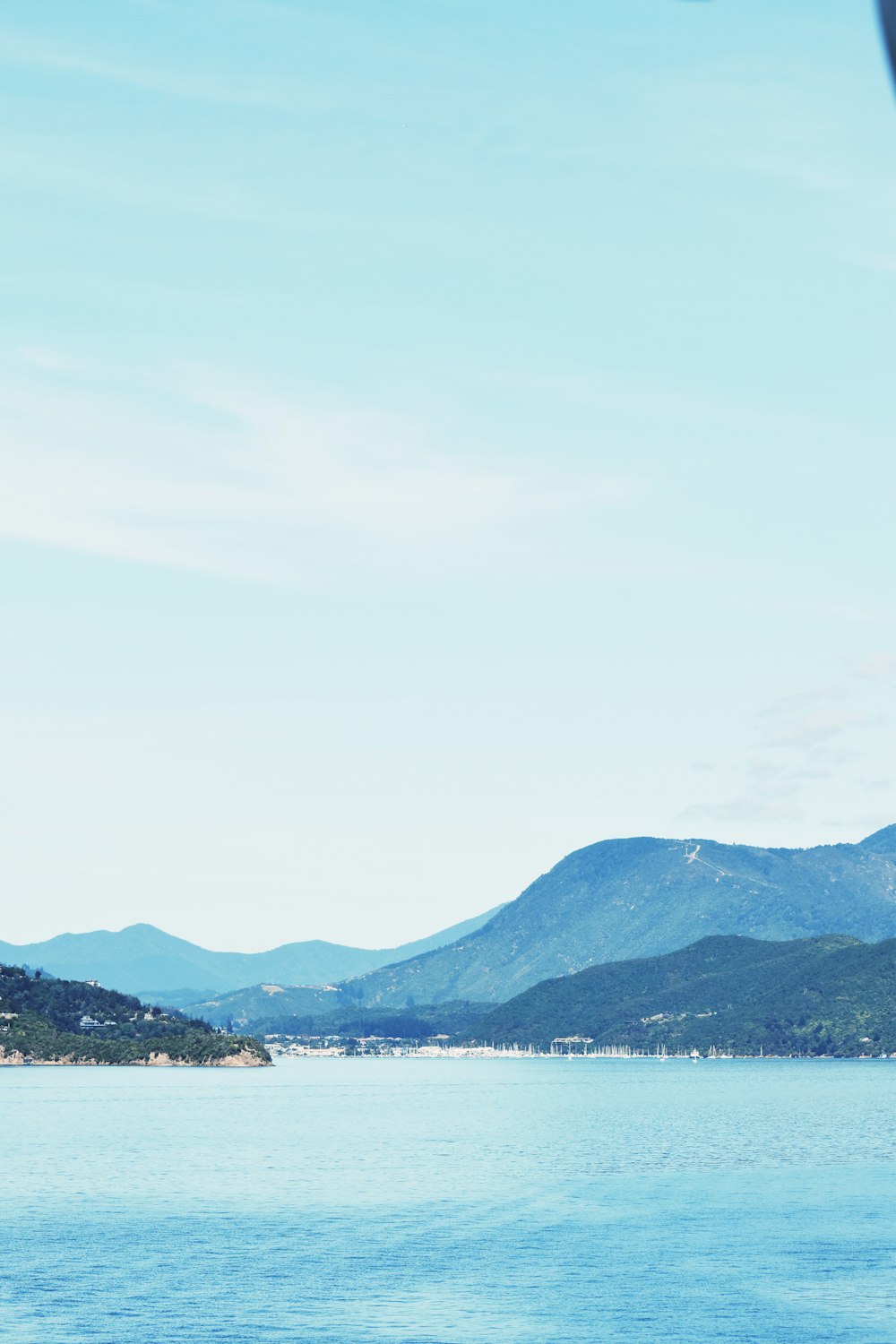 green mountains near body of water during daytime