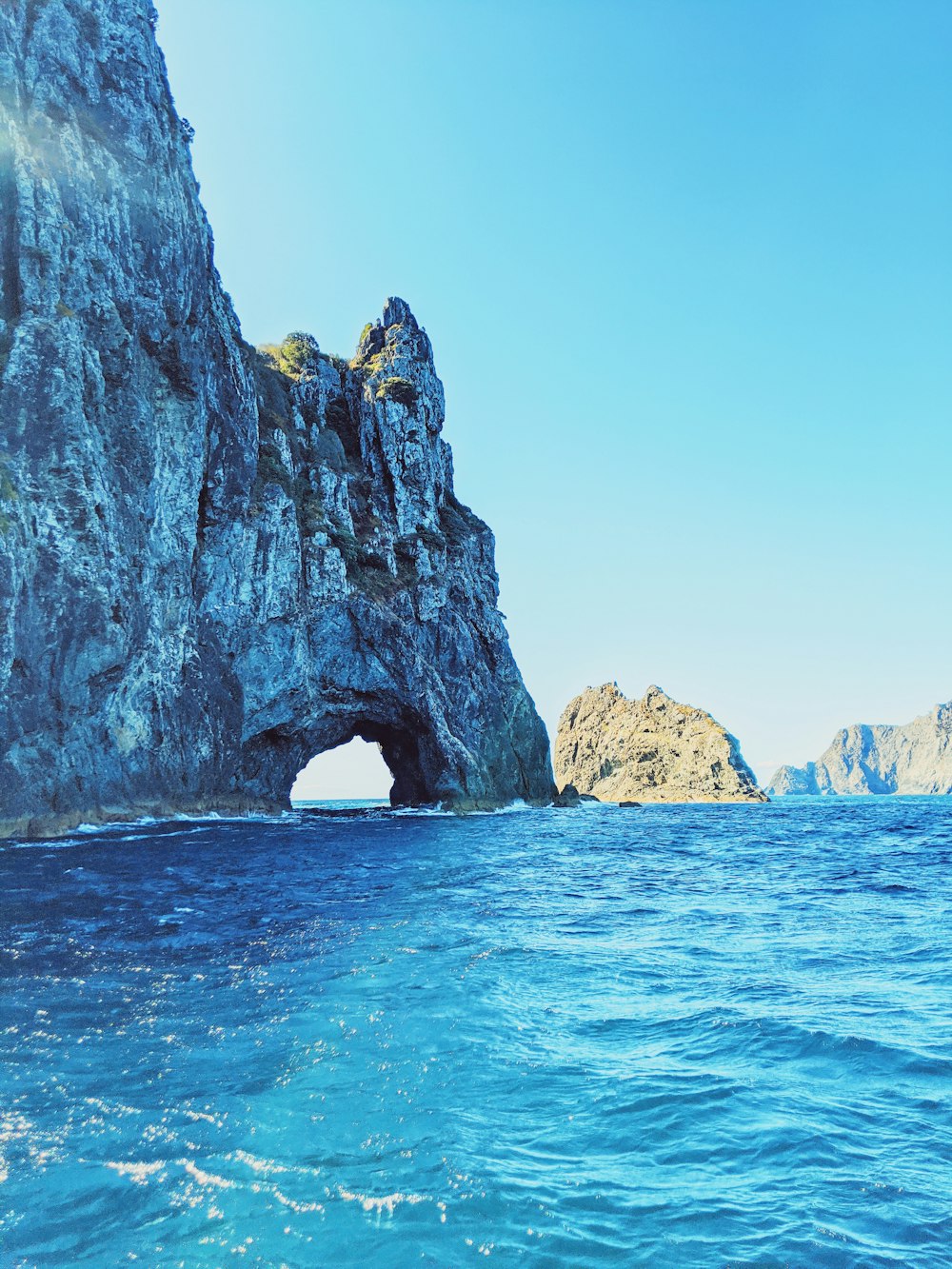 brown rock formation on blue sea under blue sky during daytime