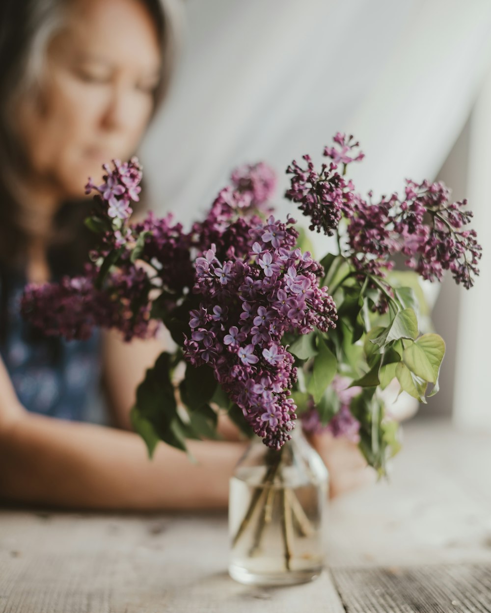 purple flowers in clear glass vase