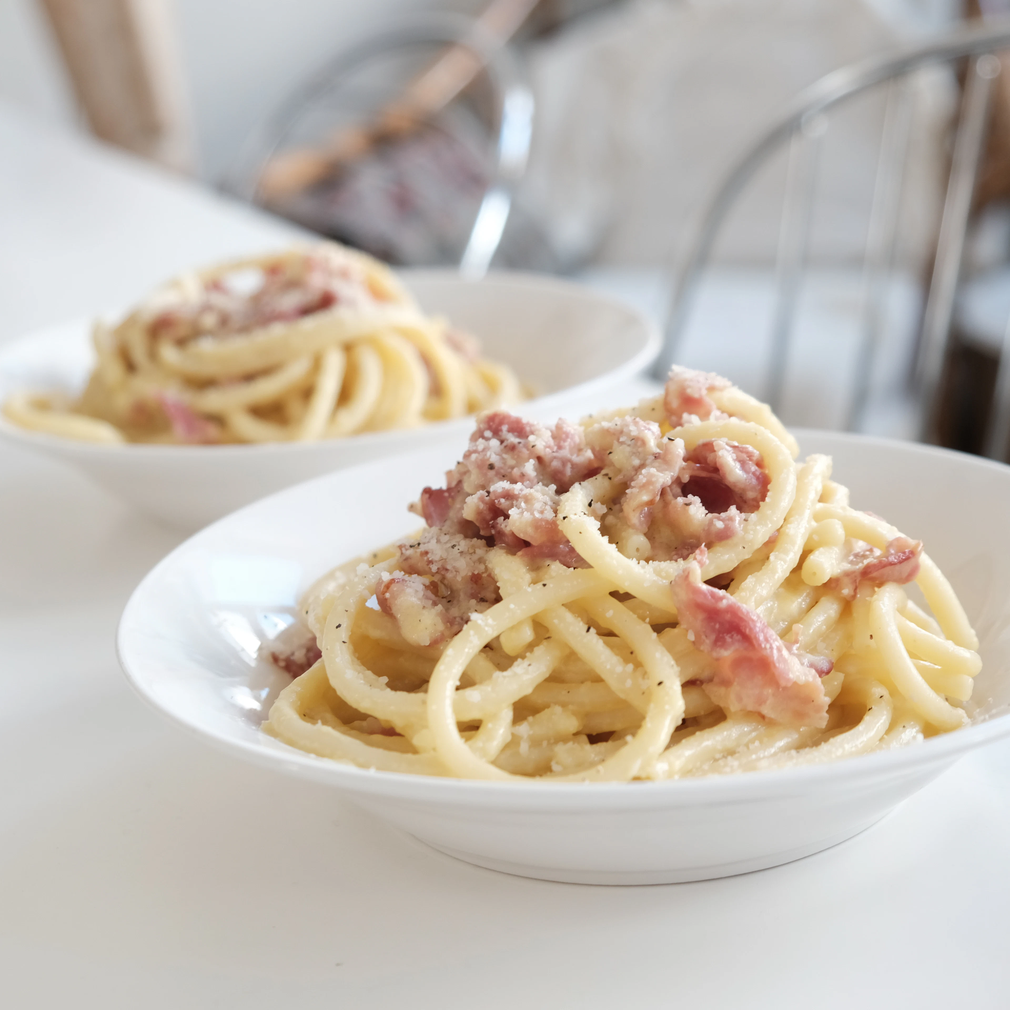 Bowls of spaghetti carbonara with silky egg sauce and pieces of guanciale