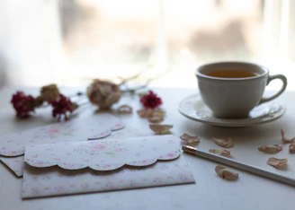 white ceramic cup on white floral saucer