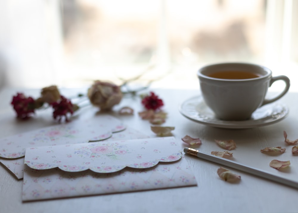 white ceramic cup on white floral saucer