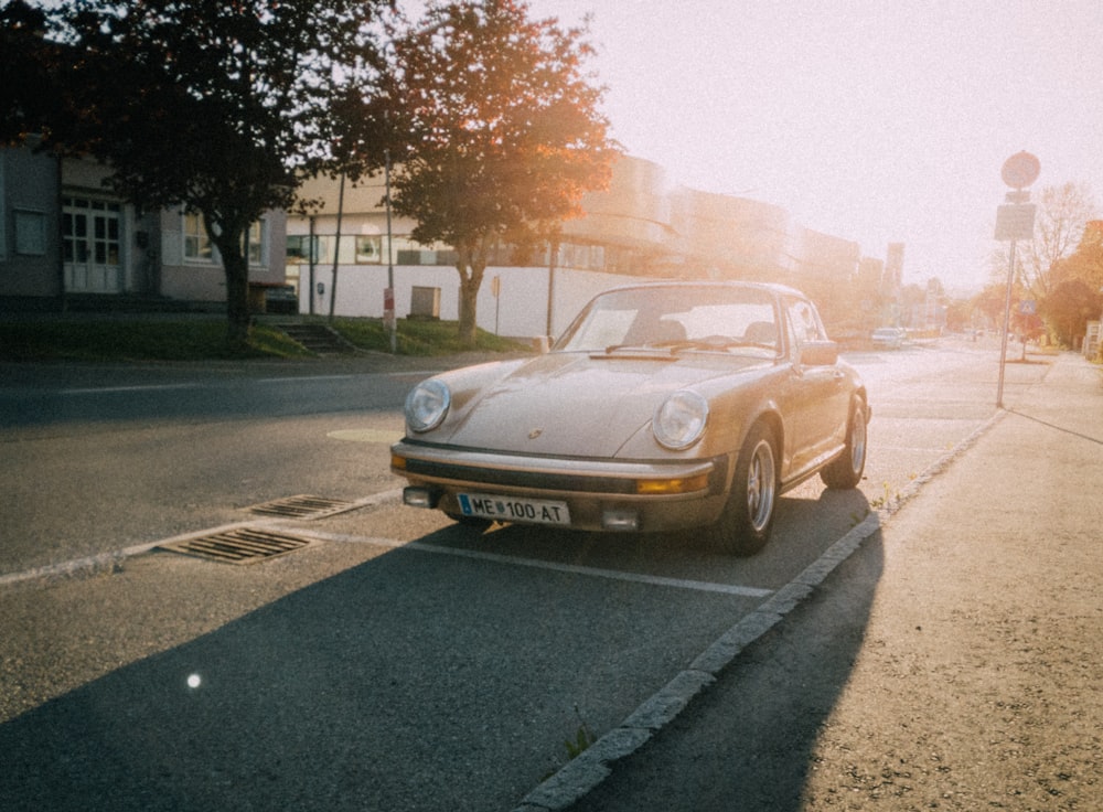 Voiture décapotable dorée sur la route au coucher du soleil