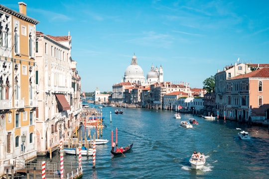 people riding on boat on river near buildings during daytime in Gallerie dell'Accademia Italy