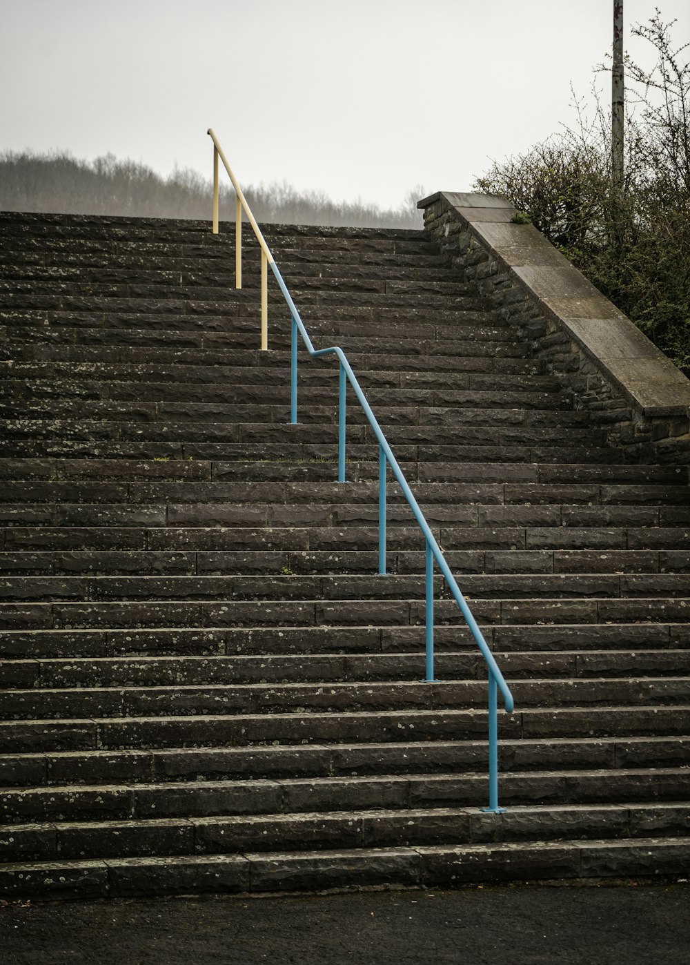 un escalier avec une main courante bleue