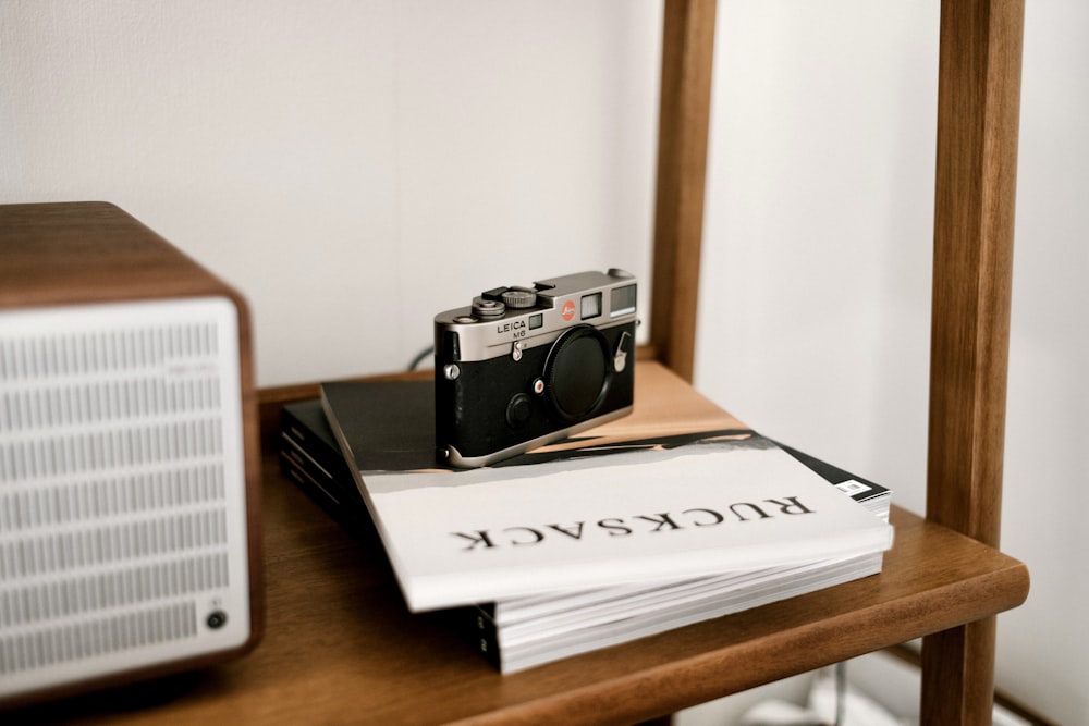 black and silver camera on white book