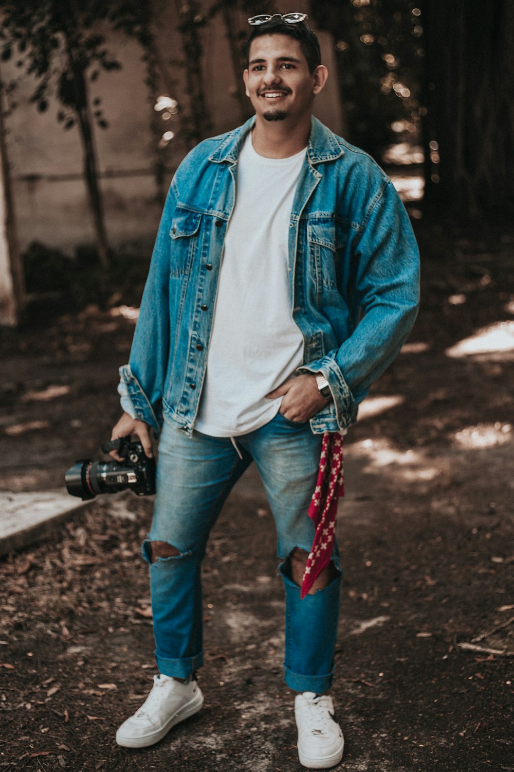 woman in blue denim jacket and blue denim jeans holding black dslr camera